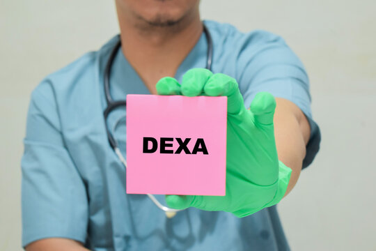 Doctor holds in hands a card with the name of the DEXA. Medical concept