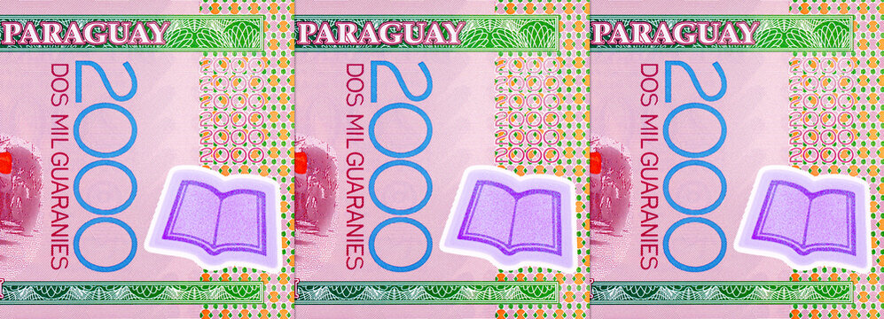 2000 Guaranies Paraguay featuring a parade of students carrying national flags. Colorful polymer currency note from South America. Money of Paraguay.