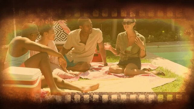 Four pals sitting by pool, man pointing sparking laugh, sharing joke, film framing group lifestyle