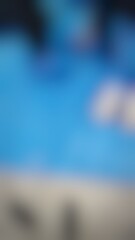 Obraz premium Person swimming in clear blue water pool with bright sunlight and reflections showcasing leisure
