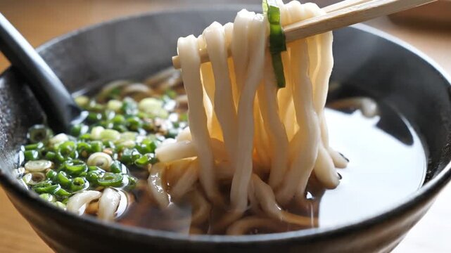 Delicious Bowl of Hot Noodle Soup with Fresh Green Onions and Broth