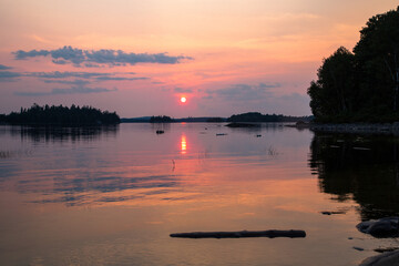 Fototapeta premium Sunset over calm lake in La Verendrye Wildlife Reserve Quebec with reflection
