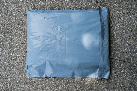 Parcel in a plastic bag on ground. Top view