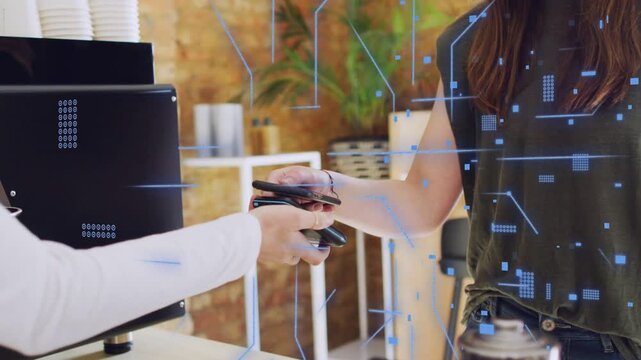 Two women completing payment customer tapping phone while staff holding card reader at cafe counter