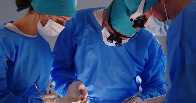 Surgeon group professional medical doctors surgical team performing surgery, doing operation, procedure on patient, surgical gown, cap, face mask, eye loupe binocular, scalp to treat injuries, disease
