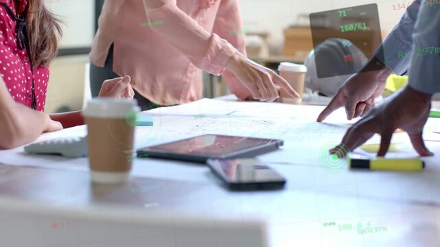 Design team leaning over blueprint center pointing while male gesturing causing HUD aligning plan