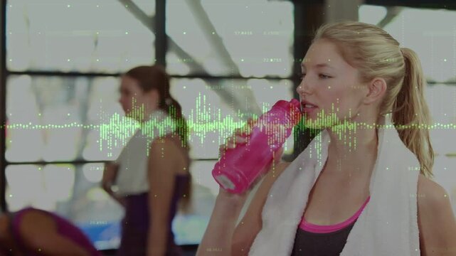 Woman lifting pink bottle and drinking in gym camera closing waveform showing hydration pointing