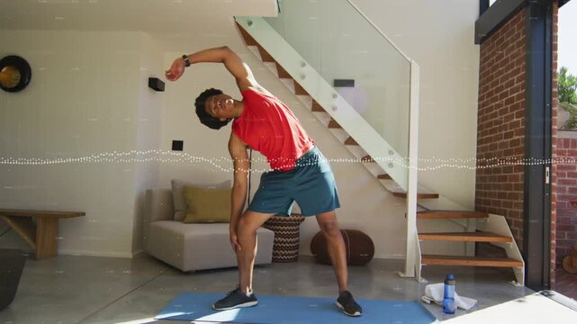 Adult man doing lateral stretches on blue mat with smartwatch, audio waveform guiding for fitness