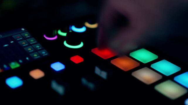 DJ sampler controller glowing pads finger pressing music production equipment Electronic beatmaker console colorful buttons dark workspace sound engineering technology interface audio mixer