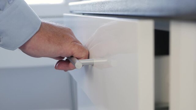 Man Opening a Drawer from  Kitchen Furniture. Businessman Checking Inside a Drawer from a Closet from Office.