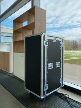 Professional flight case with reinforced metal corners and wheels for stage equipment transport. Hard shell transport container featuring butterfly latches. Heavy duty road case for touring gear.