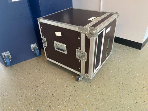 Professional flight case with reinforced metal corners and wheels for stage equipment transport. Hard shell transport container featuring butterfly latches.