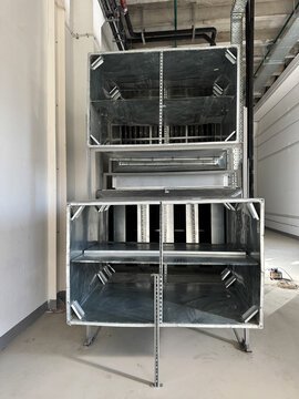 Industrial air handling unit with insulated ductwork in utility room.