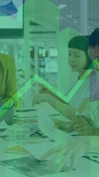 Vertical video: Left man reaching, team sharing papers and reviewing design under green graph