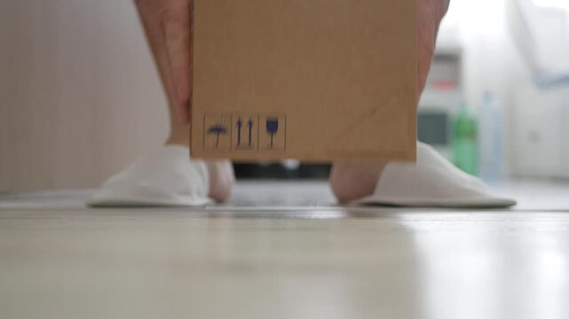 Blurred Shooting with a Man Letting at the Door a Package for Mail Courier Delivery. Concept of Postage Delivery from the Door.