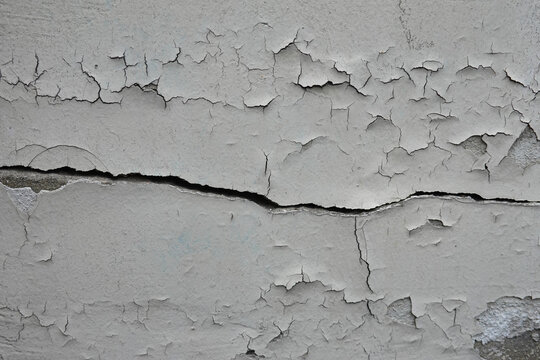 Mur endommag&eacute; et fissur&eacute; avec peinture qui s'&eacute;caille