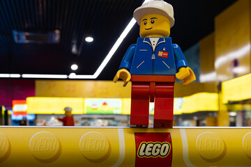 Naklejka premium LEGO worker minifigure on yellow display shelf in store