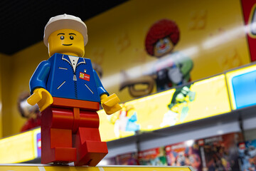 Naklejka premium LEGO worker minifigure on yellow display shelf in store