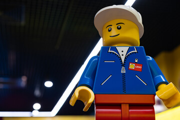 Naklejka premium LEGO worker minifigure on yellow display shelf in store