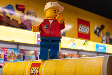 Naklejka premium LEGO worker minifigure on yellow display shelf in store