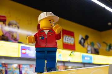 Naklejka premium LEGO worker minifigure on yellow display shelf in store