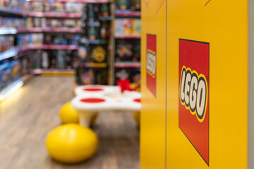 Naklejka premium LEGO brand store interior with logo on yellow display close up