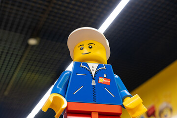 Naklejka premium LEGO worker minifigure on yellow display shelf in store