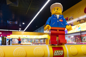 Naklejka premium LEGO worker minifigure on yellow display shelf in store