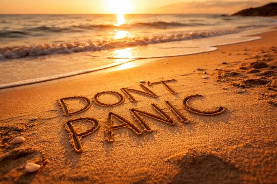 Dont Panic message etched into golden sand at sunrise
