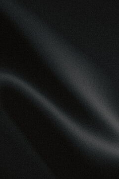 A close up view of smooth black fabric with subtle flowing curves