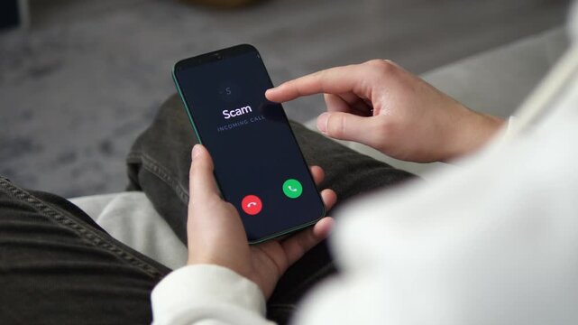 Close-up of Scam Call Alert on Mobile Phone Screen. Realistic shot of a suspicious scam call on a smartphone. Ideal for content about telemarketing fraud, consumer protection, and digital safety. 