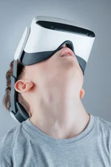 A boy enthusiastically explores the virtual world in a VR helmet © Alexander