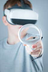A gamer wearing virtual reality glasses with controllers and a headset © Alexander