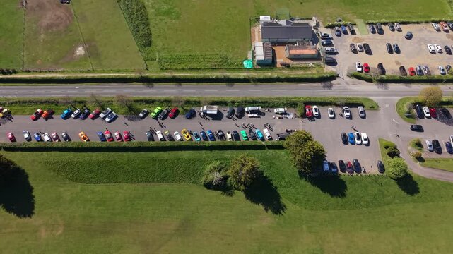 Aerial drone footage of a busy car boot sale in Fawley, Hampshire, showing rows of cars, stalls, and people gathered in an open field