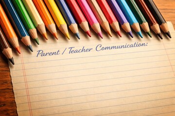 Fototapeta premium Assorted colorful pencils placed on retro lined paper for parent teacher communication