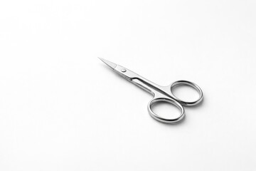Obraz premium Tiny manicure scissors showcased against a bright white surface with extensive copy space