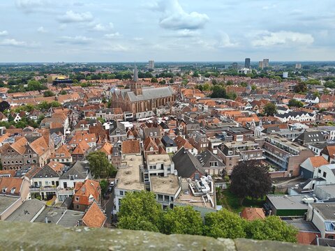 View over the historic city center of Amersfoort, Netherlands, seen from the Onze Lieve Vrouwetoren on a sunny summer day, featuring traditional Dutch architecture and rooftops.