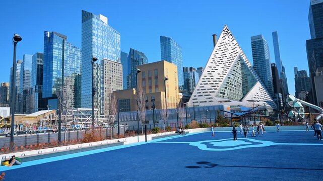 New York, USA, 2 April 2026: Residential skyscraper VIA 57 West with playground in foreground. Modern New York architecture viewed from a public park with people.