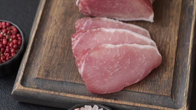 Smoked or dry cured meat slices, pork or ham with salt and spices. Smoked meat slices as a food background for your design