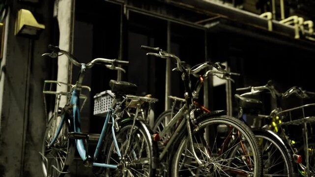 Tight closeup bicycles against architectural column, focus on wheel spokes and textured metal, shadow patterns and weathered paint create tactile composition,