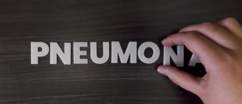 the word pneumonia written on a dark background with white block letters or capital letters (fast version) 