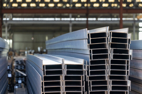 Close up view of stacked steel I beams showing clean edges and uniform profiles stored in industrial warehouse for construction and engineering applications