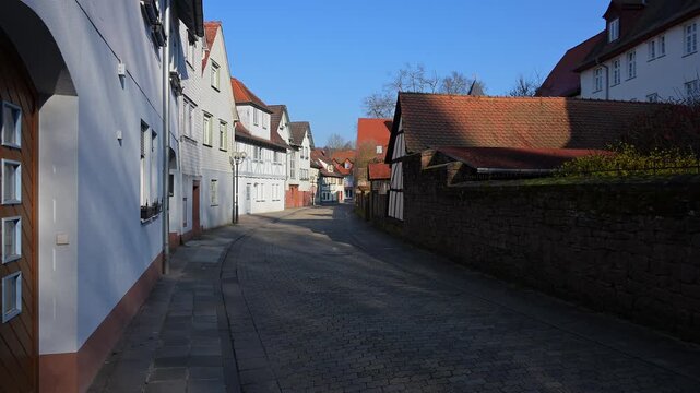 Gepflasterte Gasse ges&auml;umt von Fachwerkh&auml;usern, die einen klaren Himmel &uuml;berblickt, Am Schlossgraben, Erbach, Odenwald, Hessen, Deutschland