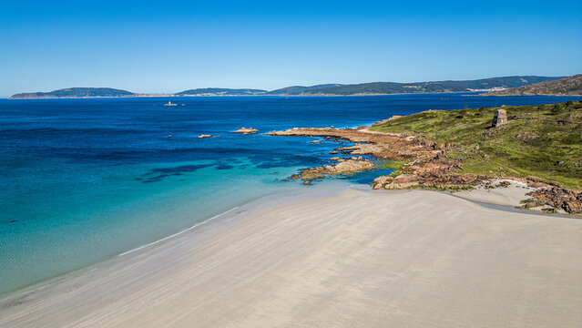 Aerial view of O Pindo beach and ancient stone tower, Galicia, Spain.