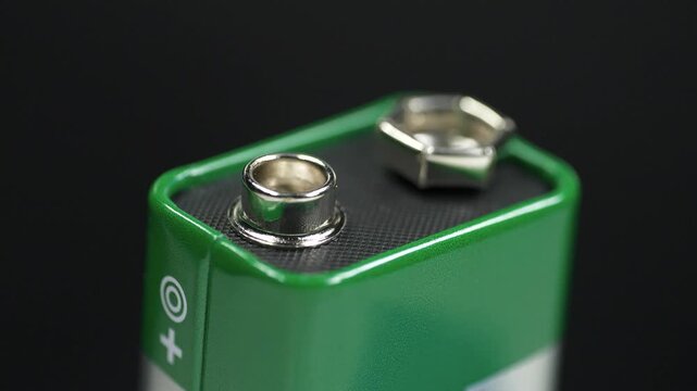 9-volt battery with terminals isolated, green electric battery delivering nominal voltage of 9 volts and ready for connection to electronic devices