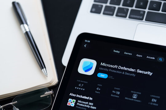 Microsoft Defender Security app on iPad with Apple Liquid Glass updated look and iOS 26 design on desk beside notebook and laptop. Stafford, United Kingdom, April 13, 2026.