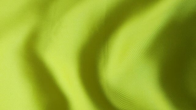 Natural silk fabric waving in wind creating abstract background. Bright lime and yellow textile surface with fluid motion and soft waves. Solid neon green material forming organic texture.