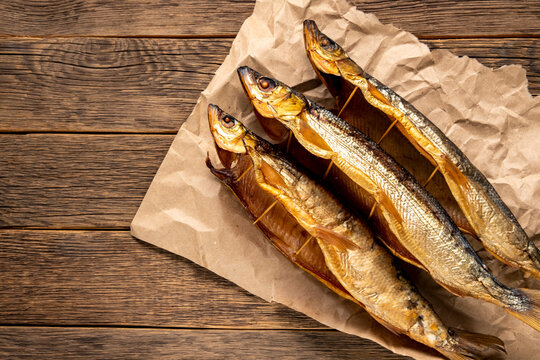Hot smoked fish Baikal omul Coregonus autumnalis on wooden table