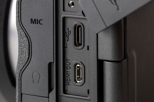 Detailed macro shot of professional camera interfaces featuring USB TYPE-C and HDMI OUT ports, close-up of side connection panel with microphone and headphone icons on black body