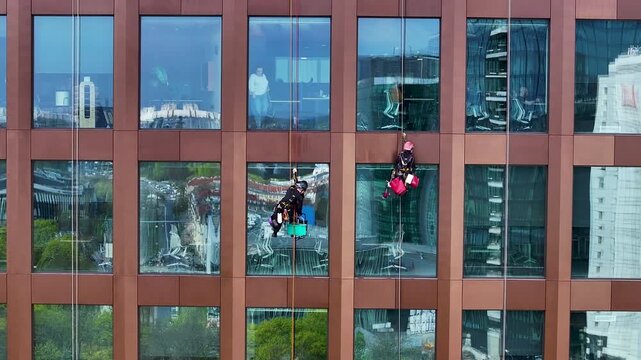 Aerial window washers on high rise building Poland close 1. Historical capital Greater Poland. Academic, scientific, cultural center. Metropolitan area with modern high rise business and apartments.